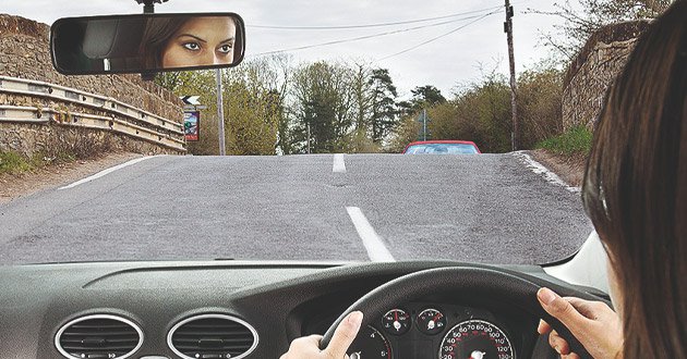 Over shoulder of driver, approaching brow of hill, day.