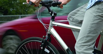 Cyclist and car passing in a blur.