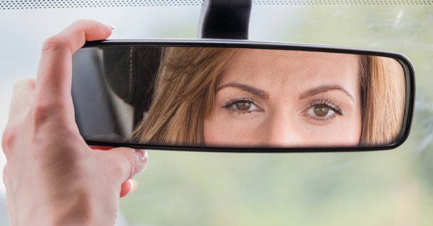 Lady's reflection in rear view mirror.