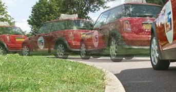 Time-lapsed image of car reversing in 4 stages around left hand bend, day.