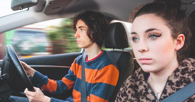 Young male with female passenger, driving, day.