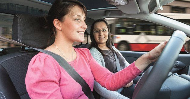 Young female learner driver at the wheel with a female instructor.