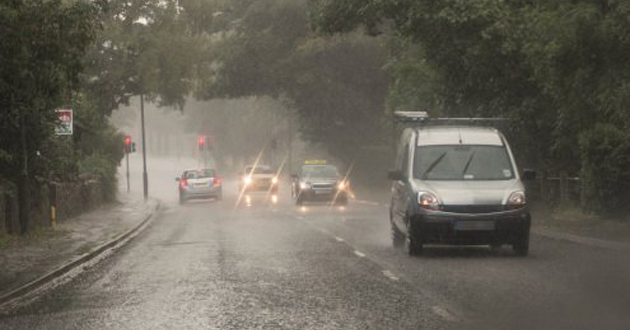 Car driving in wet conditions in summer.